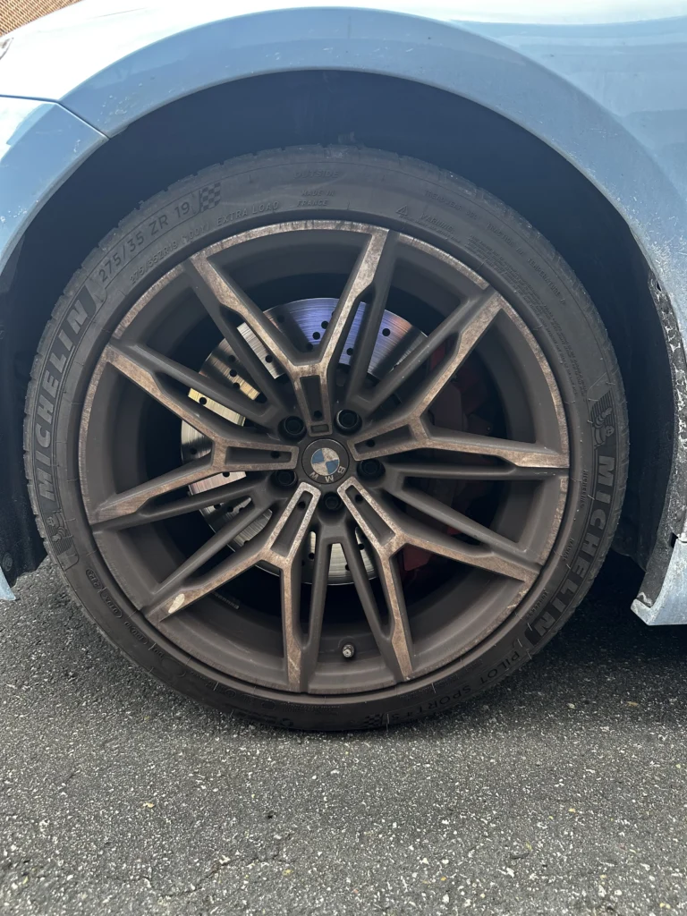 Wheel before detailing — covered in brake dust